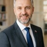 Портрет уверенного российского бизнесмена в студийном освещении на размытом нейтральном фоне для сайта